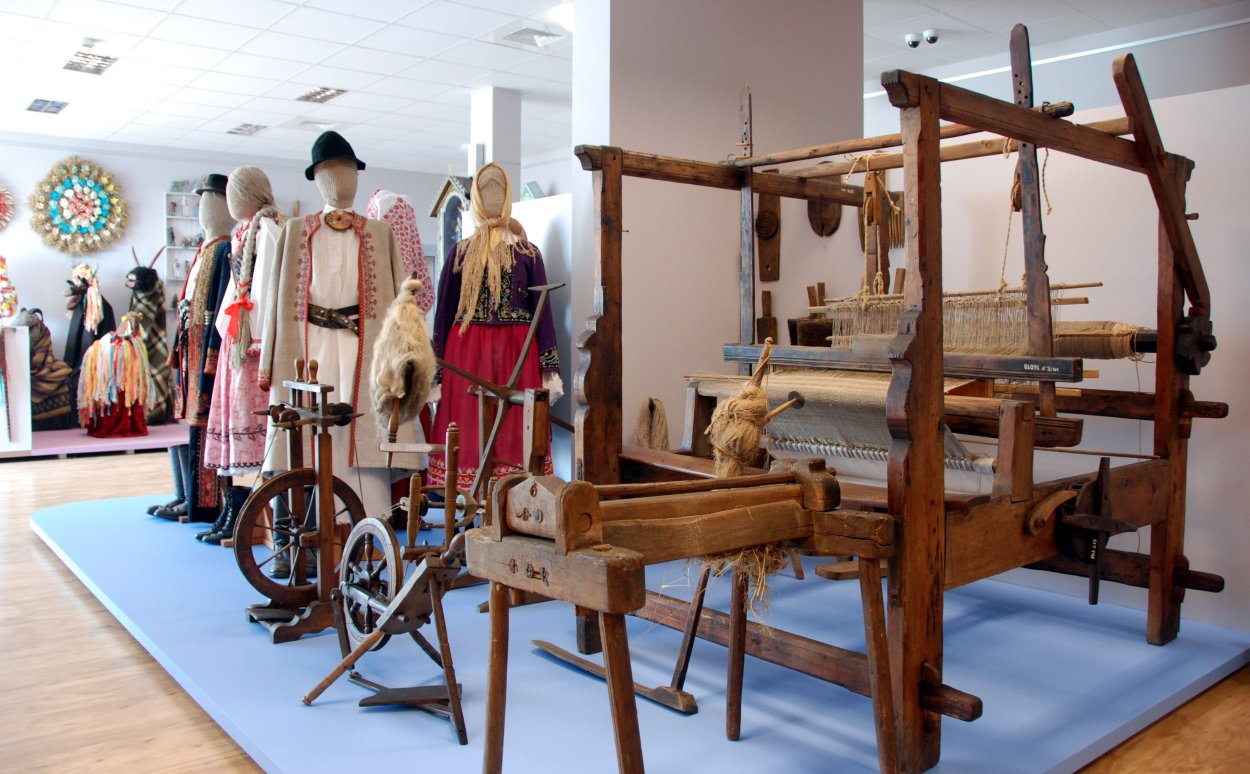 Museum hall - mannequins in folk costumes, looms, reel