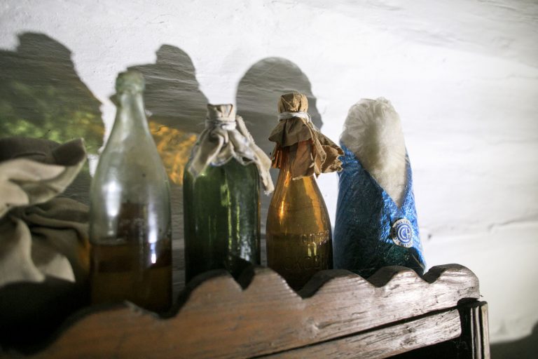 butelki i głowa cukru na półce