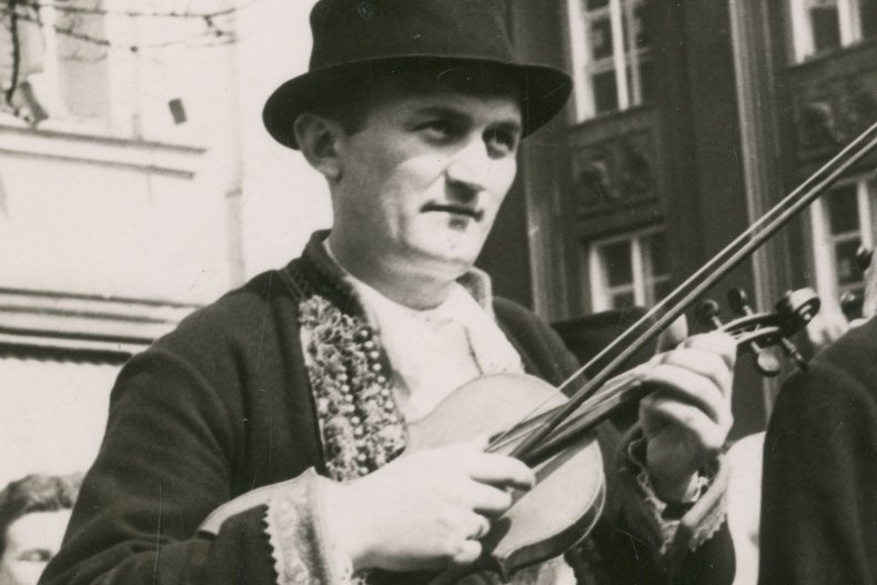 Mężczyzna w stroju ludowym gra na skrzypcach