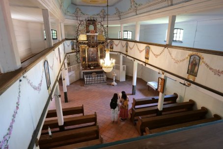 Dwie osoby we wnętrzu kościoła ewangelickiego