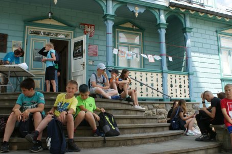Dzieci siedzą na schodach przed muzeum