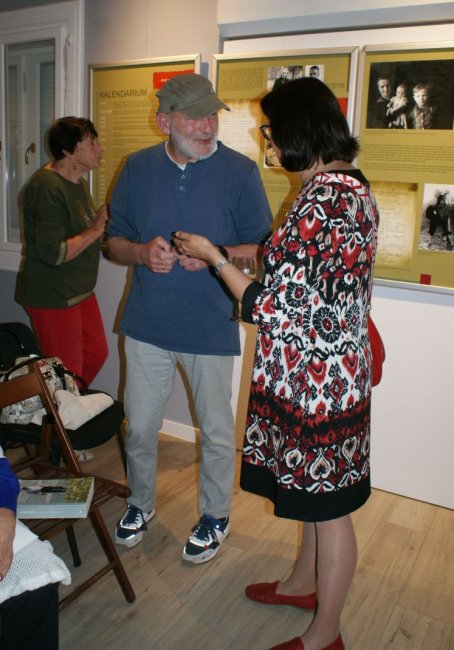 Kobieta rozmawia z mężczyzną, w tle wystawa.