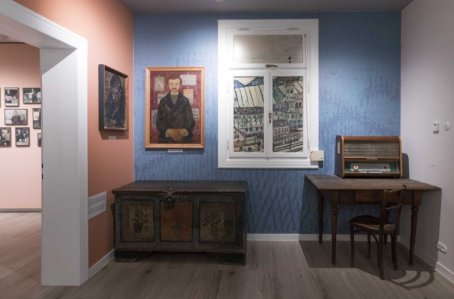 Mały pokój z obrazami , skrzynią i biurkiem