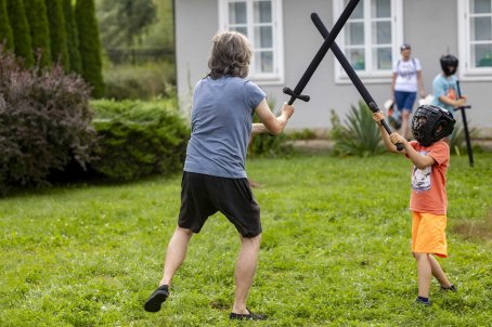 dzieci walczą drewnianymi mieczami