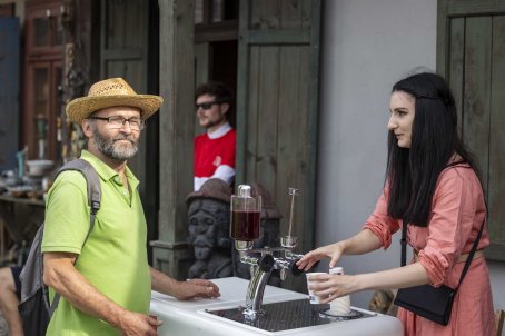 kobieta podaje wodę mężczyźnie w kapeluszu