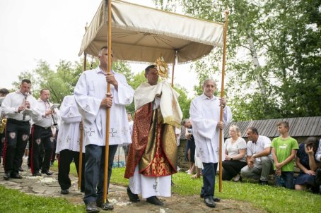 22.	Ksiądz trzyma monstrancję, za nim mężczyźni trzymają baldachim, w tle ludzie.