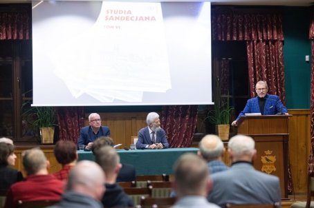 mężczyzna przy mikrofonie, ludzie słuchają