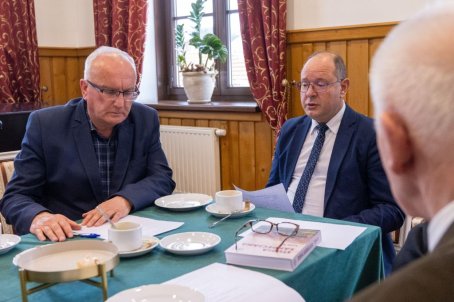 trzech mężczyzna rozmawia przy stole