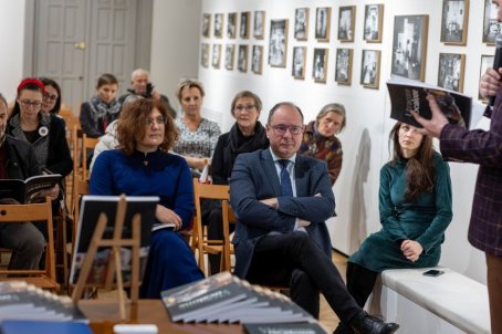 Zebrani na sali słuchają siedząc