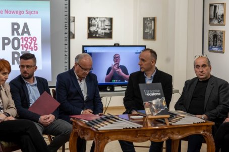 Mężczyźni i kobieta siedzą przy stolikach