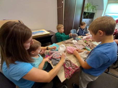 Dzieci i rodzice robią lalki z gałganków