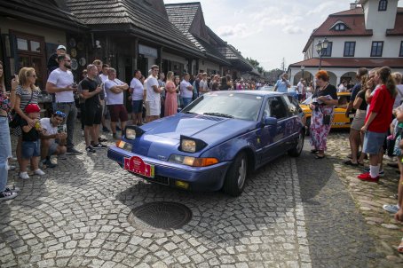 30.	Samochody, wokół nich ludzie, w tle budynki