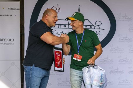 44.	Mężczyźni trzymają nagrody i podają sobie ręce.