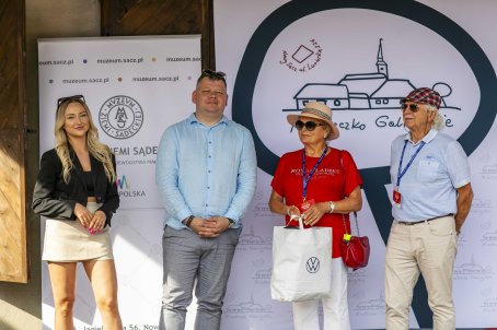 48.	Cztery osoby na scenie, jedna z nich trzyma nagrodę