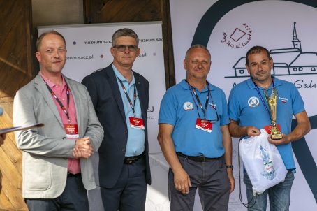 50.	Czterech mężczyzn na scenie, jeden z nich trzyma puchar.